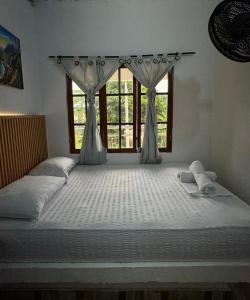 a large bed in a room with a window at Quinto Hotel in Palomino