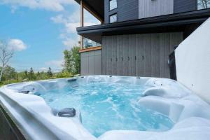 a hot tub on the side of a building at Käbane OPeak - Mezzanine sur le Fleuve in Les Éboulements