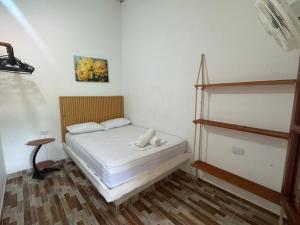 a small bedroom with a bed and a shelf at Quinto Hotel in Palomino