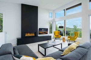 a living room with a couch and a fireplace at Käbane OPeak - Mezzanine sur le Fleuve in Les Éboulements