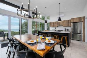 a kitchen and dining room with a wooden table and chairs at Käbane OPeak - Mezzanine sur le Fleuve in Les Éboulements
