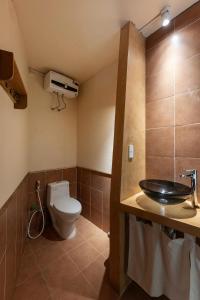 a bathroom with a toilet and a sink at HiuHill House in Cồn Giả Viên
