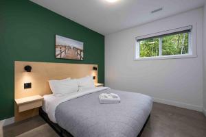 a bedroom with a bed and a green wall at Käbane OPeak - Mezzanine sur le Fleuve in Les Éboulements +23 photos