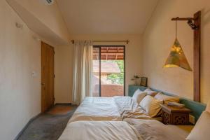 a bedroom with a bed and a window at HiuHill House in Cồn Giả Viên