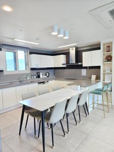 a kitchen with a long table and chairs in it at 이스턴뷰 프리미엄 레지던스 100프로오션뷰 in Ulsan