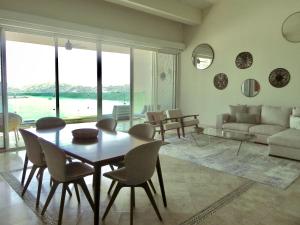 a living room with a table and chairs and a couch at B Esmeralda Pichilingue PentHouse in Acapulco +36 photos
