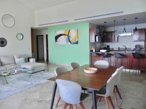 a dining room and living room with a table and chairs at B Esmeralda Pichilingue PentHouse in Acapulco