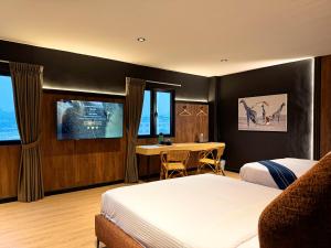 a hotel room with two beds and a table at Bonbon Hotel in Kluang
