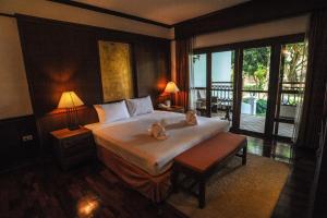 a bedroom with a bed with two stuffed animals on it at Suan Bua Hotel & Resort in Ban Pong +35 photos