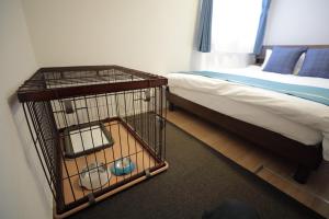 a bird cage next to a bed in a room at Casa Stella 8 by Liaison カーサステラ8 byリエゾン in Osaka