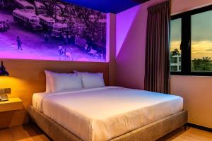 a bedroom with a large bed with a purple lighting at Bonbon Hotel in Kluang