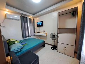 a small bedroom with a bed and a desk at Seaview Transient House in Bucayao