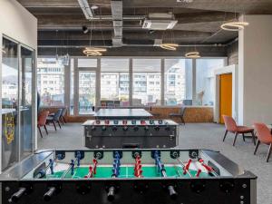 a room with a pool table and ping pong tables at ibis Styles Ljubljana Centre in Ljubljana