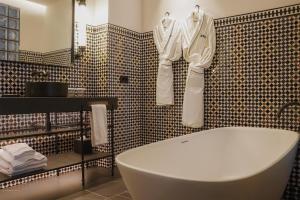 a bathroom with a white robe hanging on a wall at Thompson Seville, by Hyatt in Seville