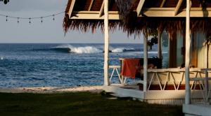 a beach house with a table and the ocean at Adams Villas in Katiet