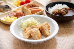 a white bowl filled with food on top of a table at le Lac HOTEL KUSATSU in Kusatsu