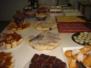 una mesa con muchos tipos diferentes de comida en ella en Hotel Piacenza, en Caxias do Sul