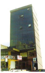 un edificio alto con letreros a un lado. en Hotel Piacenza, en Caxias do Sul
