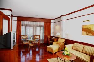 a living room with a couch and a table at Suan Bua Hotel & Resort in Ban Pong