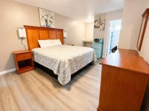 a bedroom with a bed with a wooden headboard at Royal Gateway Motel in Bend