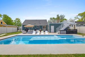 a swimming pool in front of a house at Lambeau View Pool Rooftop Entertainment Room in Green Bay