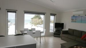 a living room with a couch and a table at Iconic Luxury & Ocean Views in Apollo Bay