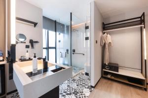 a bathroom with a glass shower and a sink at Wanda Moments Nanchang in Xinjian