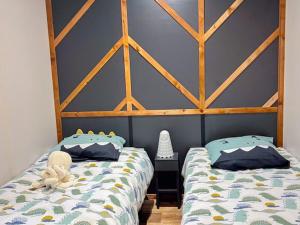a bedroom with two beds and a blue wall at Chalet avec animaux admis - 4 pers. - API-1-52-2772 in Sainte-Montaine