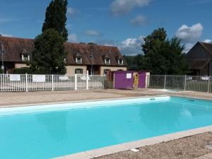 a blue swimming pool in front of some houses at Chalet avec animaux admis - 4 pers. - API-1-52-2772 in Sainte-Montaine
