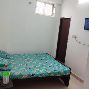 a small bedroom with a bed with a green comforter at Shifa Home Near Apollo Sankara Nethralaya Main Hospital in Chennai +15 photos