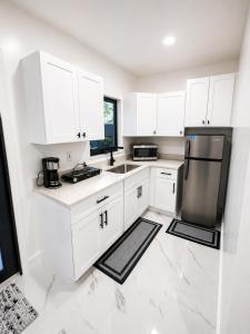 a kitchen with white cabinets and a black refrigerator at MG Realty Luxury Stay in Miami