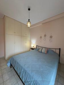 a bedroom with a bed with a blue comforter at Seaside Apartment in Vrachati