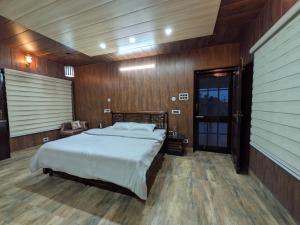 a bedroom with a large bed and wooden walls at The Cloud Cradle in Lāhri +26 photos