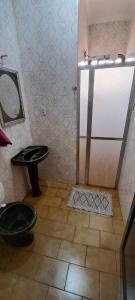 a bathroom with a shower and a toilet and a sink at Casa Próxima ao Parque do Peão in Barretos