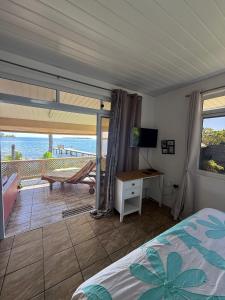 a bedroom with a bed and a view of the ocean at Fare Holidays - Raiatea in Taputapuapea
