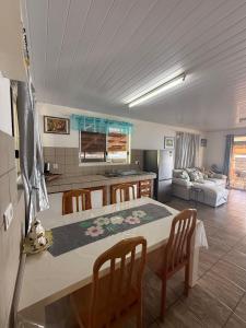 a kitchen and living room with a table and chairs at Fare Holidays - Raiatea in Taputapuapea