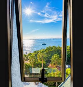 a window with a view of the ocean at Apartamento Vista Ponte in Niterói +15 photos
