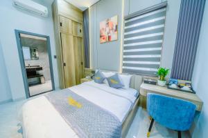 a small bedroom with a bed and a blue chair at Tan Son Nhat Airport - Golden Sun Hotel in Ho Chi Minh City
