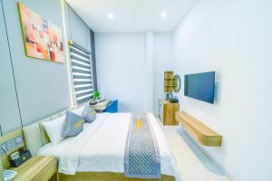 a bedroom with a large bed and a tv at Tan Son Nhat Airport - Golden Sun Hotel in Ho Chi Minh City