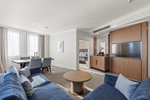 a living room with a blue couch and a table at Distinction Christchurch Hotel in Christchurch