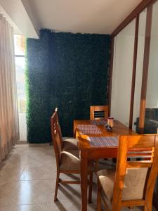 a dining room with a table and a green wall at Departamento Ebenezer in Matarani