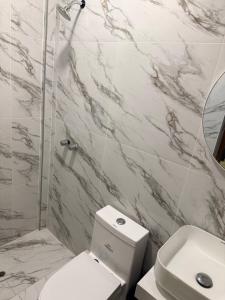 a white bathroom with a toilet and a sink at Departamento Ebenezer in Matarani