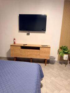 a living room with a tv on a wall at Departamento Ebenezer in Matarani