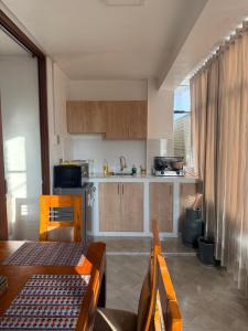 a kitchen with wooden cabinets and a table and chairs at Departamento Ebenezer in Matarani