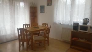 ein Esszimmer mit einem Tisch, Stühlen und einer Mikrowelle in der Unterkunft Apartment Lipno in Lipno nad Vltavou