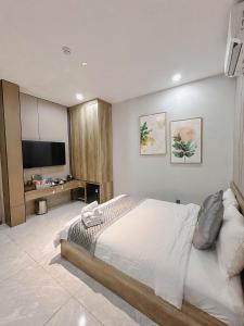 a bedroom with a bed and a flat screen tv at Tan Son Nhat Airport - Golden Sun Hotel in Ho Chi Minh City