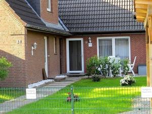 a brick house with a fence in front of it at Haushaelfte-Kuddel-104 in Böhl +6 photos