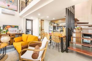 a living room with a yellow couch and a kitchen at Rain Airport Bed and Breakfast in Manila