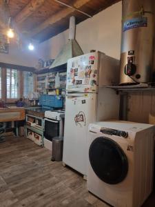 a kitchen with a refrigerator and a washing machine at Mountain House with Wonderful View in Las Compuertas
