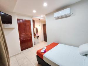 ein Hotelzimmer mit einem Bett mit einer Fernbedienung darauf in der Unterkunft Hotel Tradicional Savaro SA de CV in Zihuatanejo + 15 Fotos
